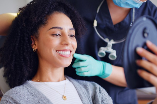 Women smiling in dentist chair with mirror